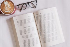book near eyeglasses and cappuccino