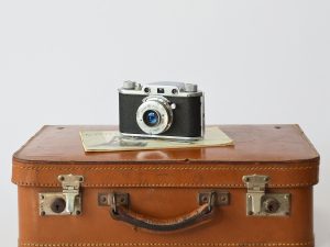 a camera sitting on top of a brown suitcase
