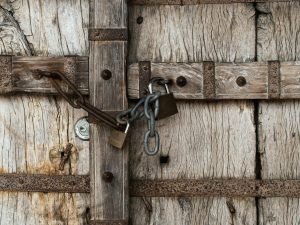brown wooden door with padlock